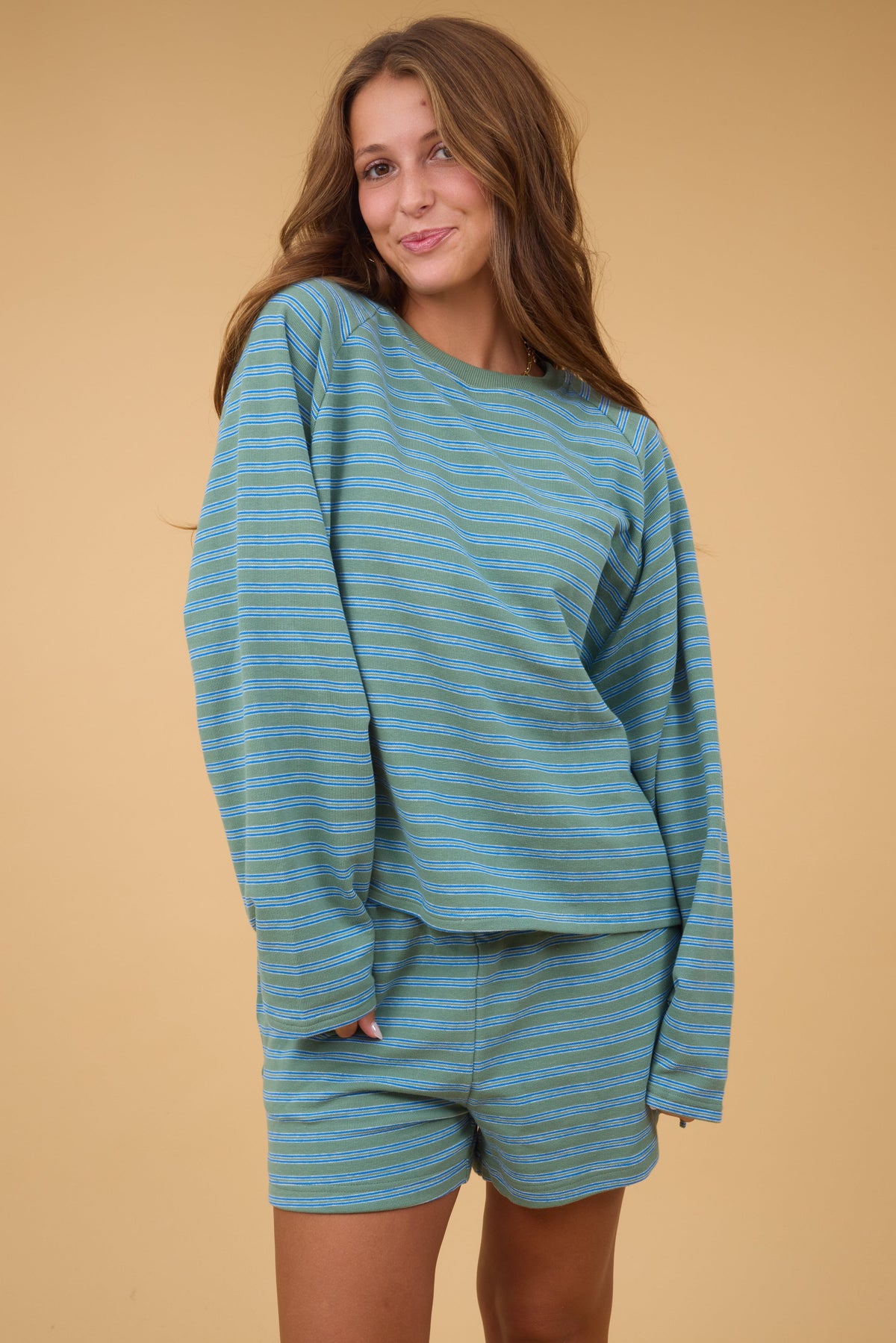 Woman wearing a 2 piece, long sleeve  shorts set in green & grey stripe with matching shorts.