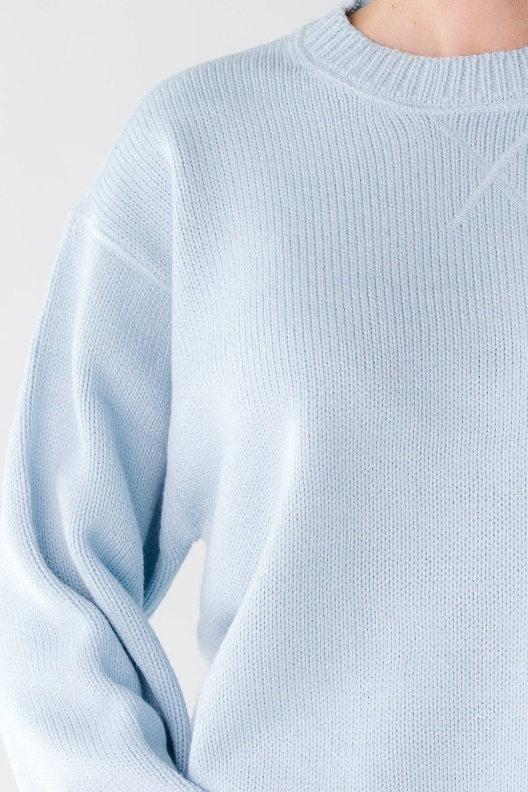 Close up of a woman wearing an light blue sweater