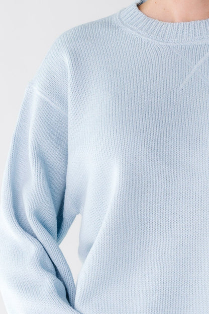 Close up of a woman wearing an light blue sweater