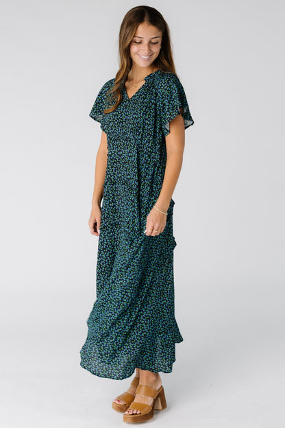 Woman wearing a blue and black tiered maxi dress  with a V-neckline