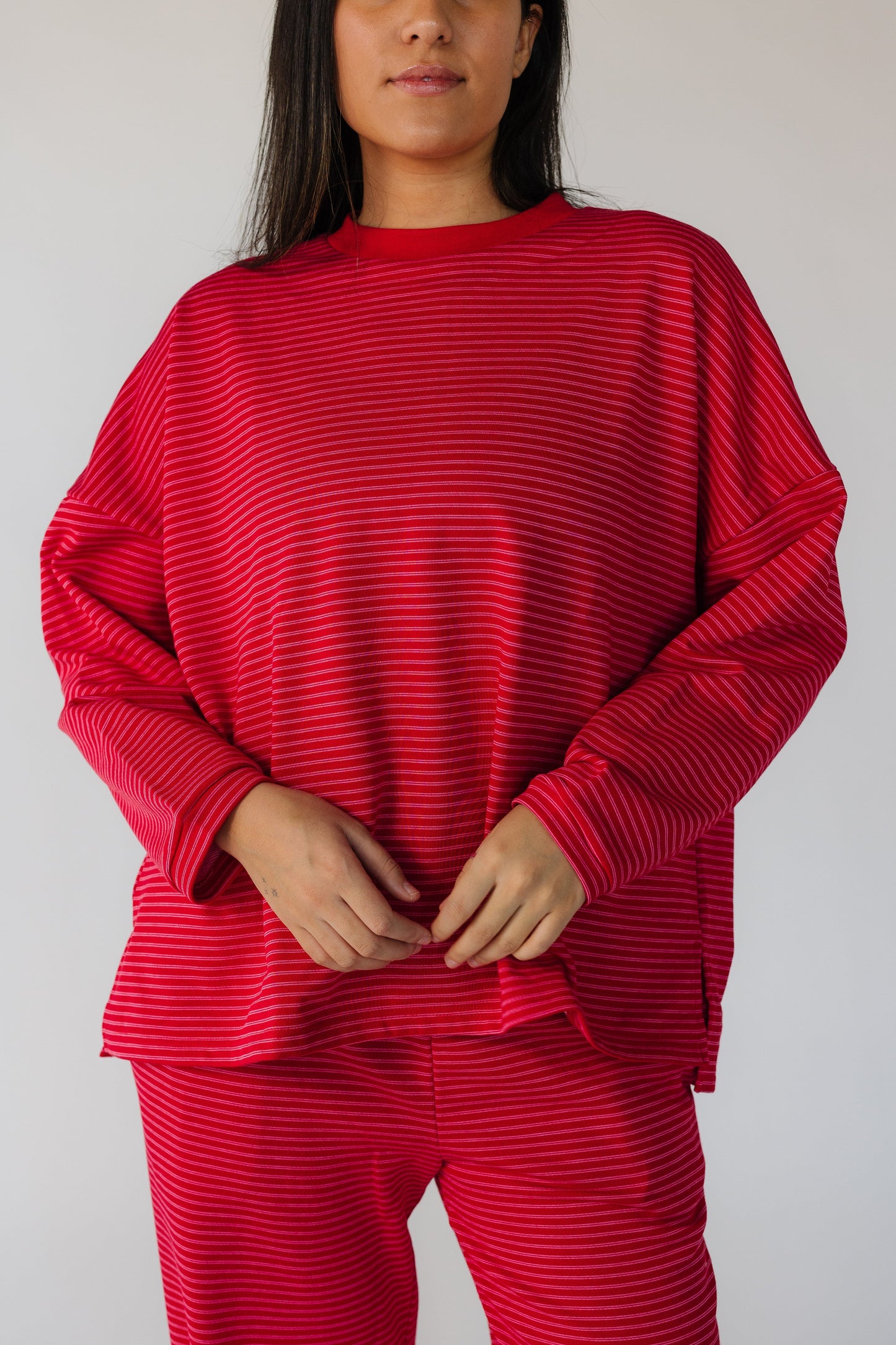 Close view of a woman wearing a red stripe lounge set with long sleeves.