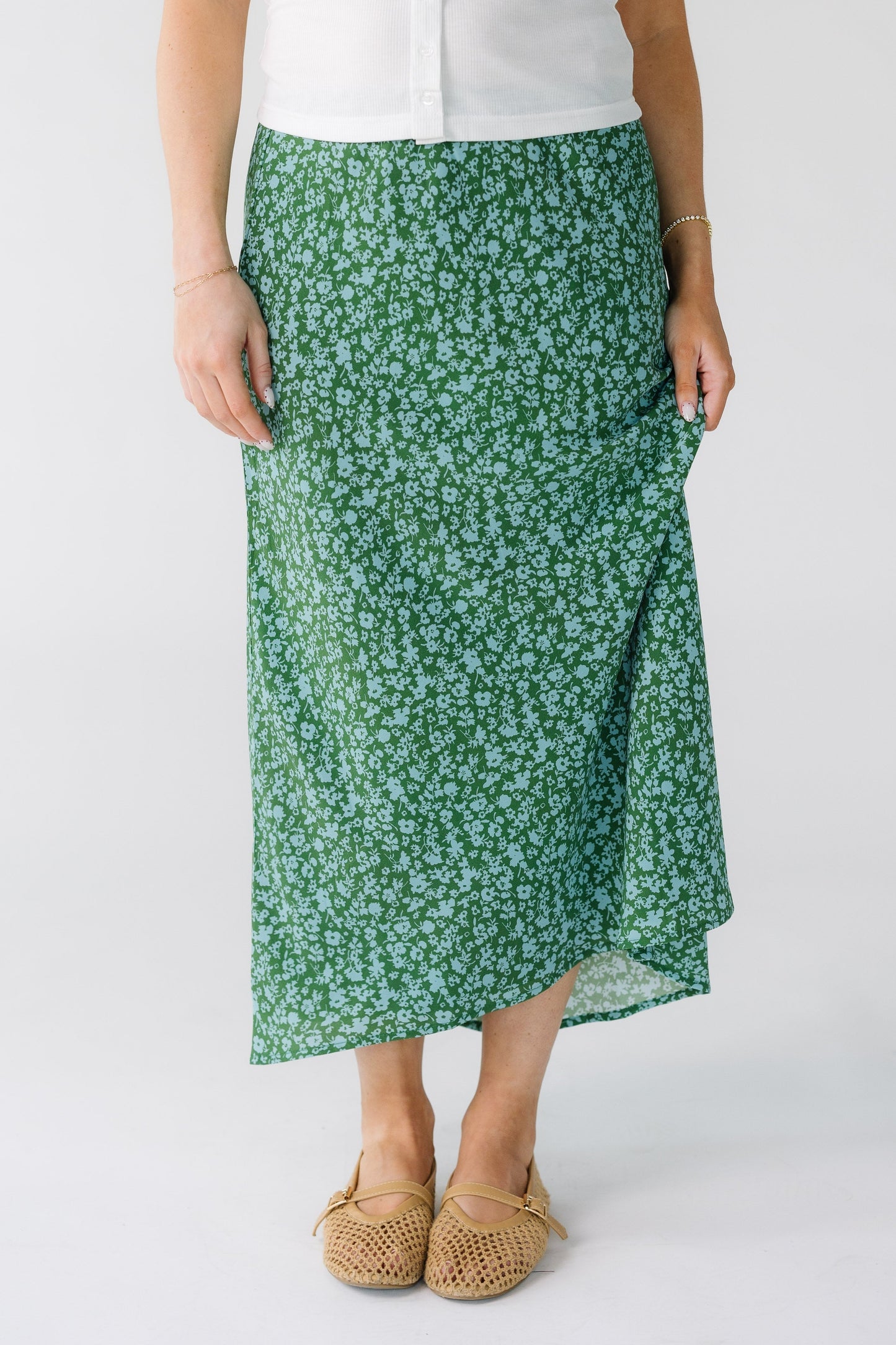 Woman wearing a modest green and light blue A-line midi skirt.