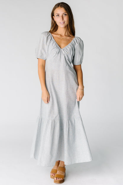 Woman wearing a white and navy stripe midi-maxi dress with short sleeves