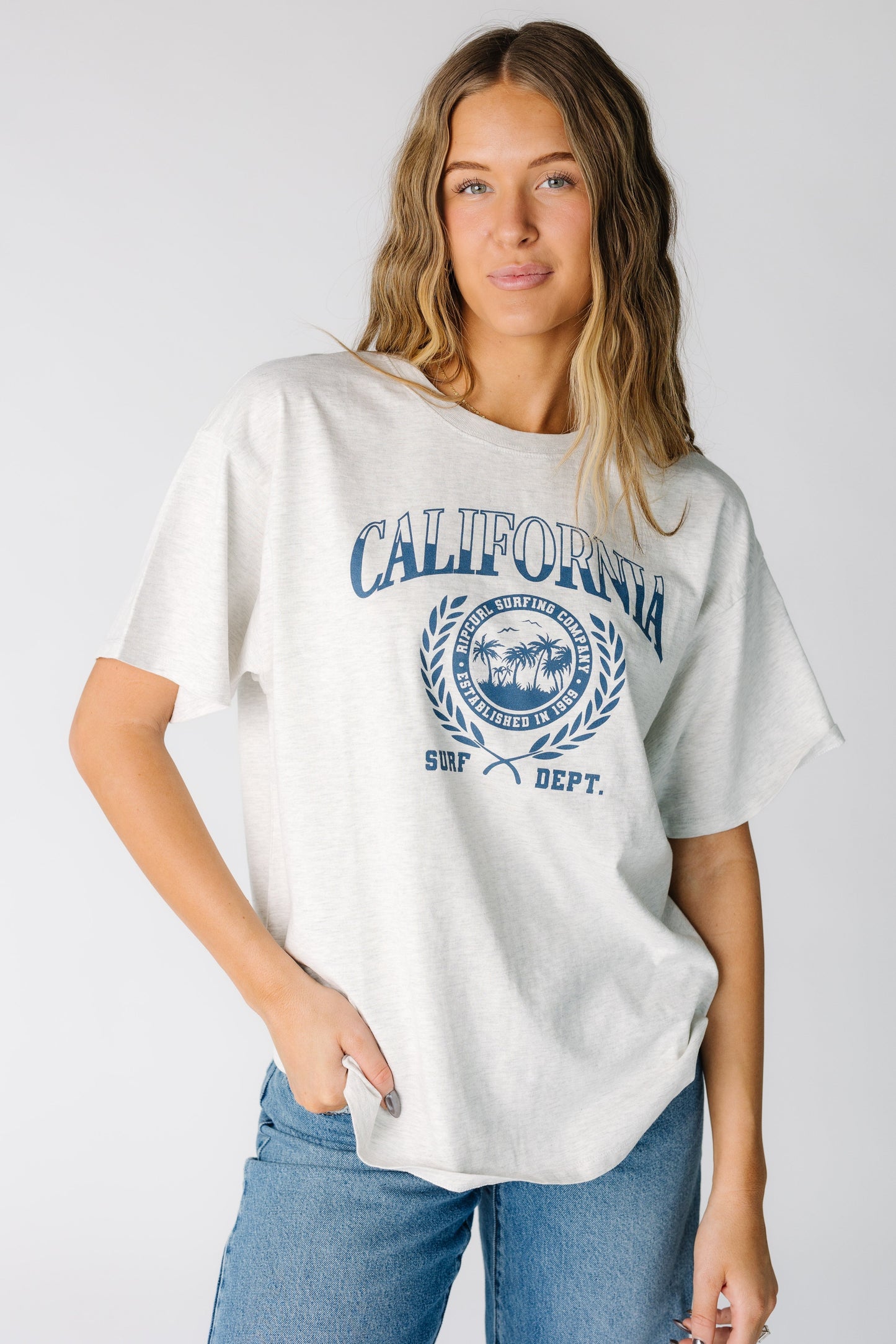 Woman wearing a Rip Curl short sleeve tee with a large front graphic 0JZWTE