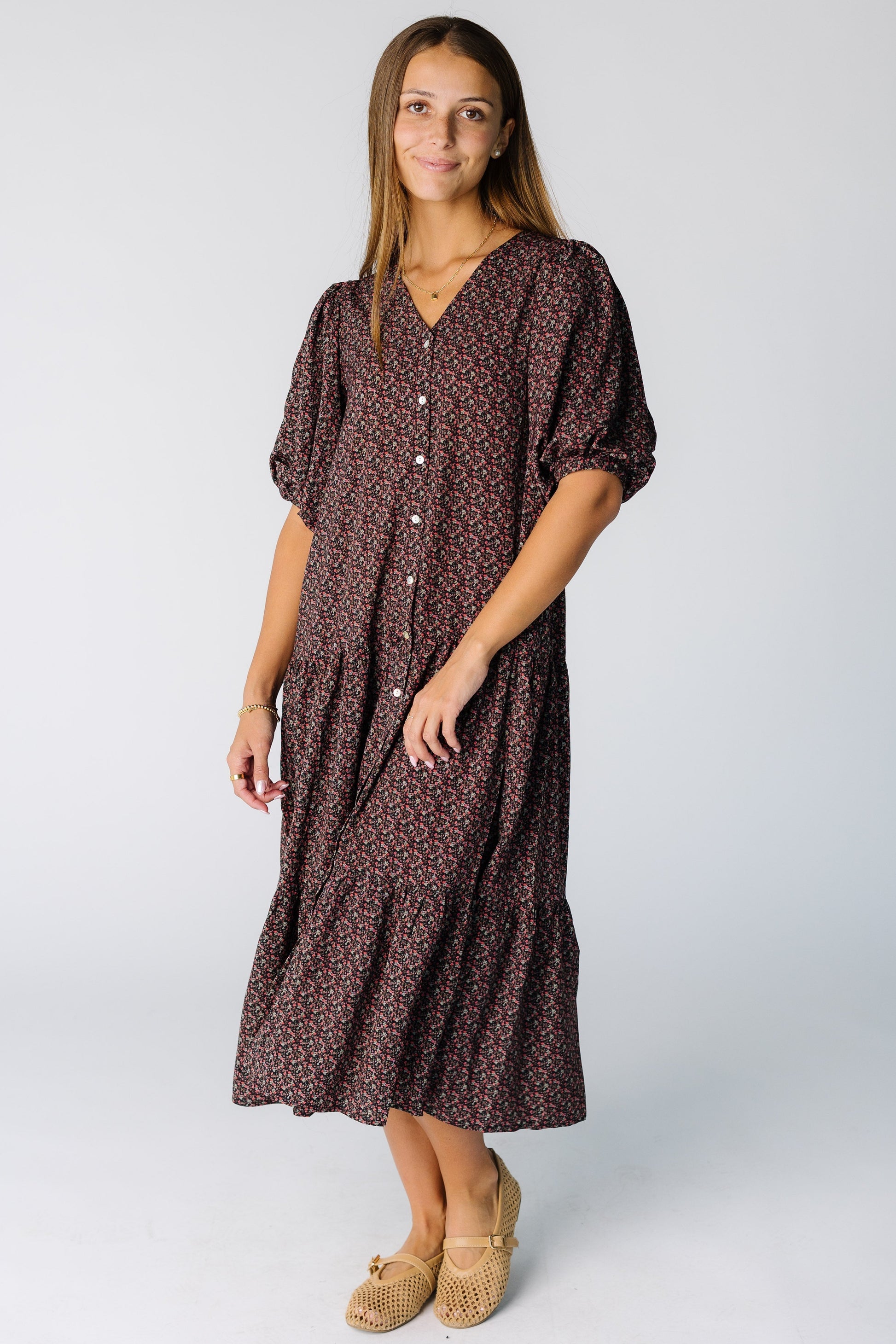 Woman wearing a modest button down midi dress with a V-neckline and elbow length sleeves