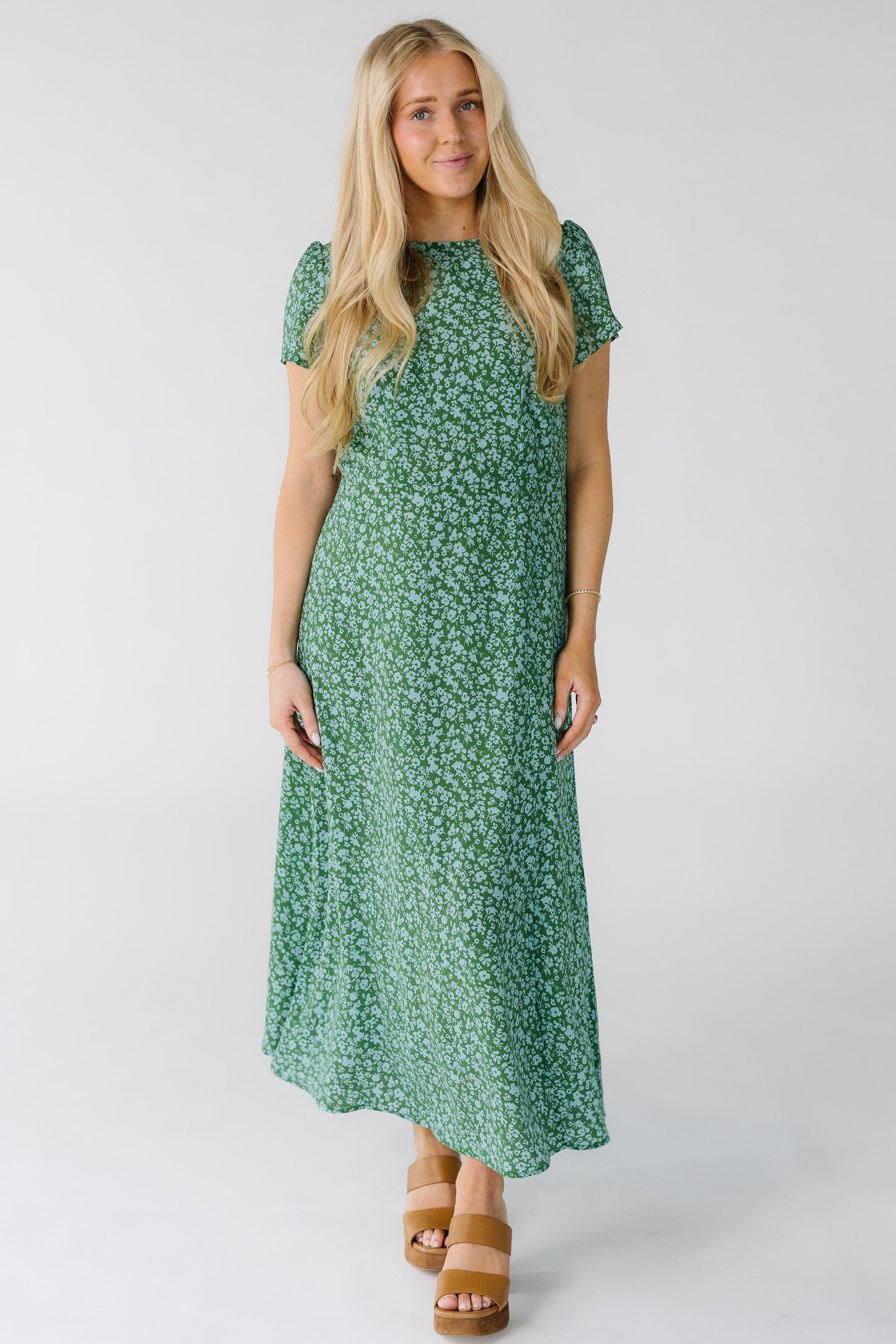 Woman wearing a green and light blue closer fitting midi dress with short sleeves.