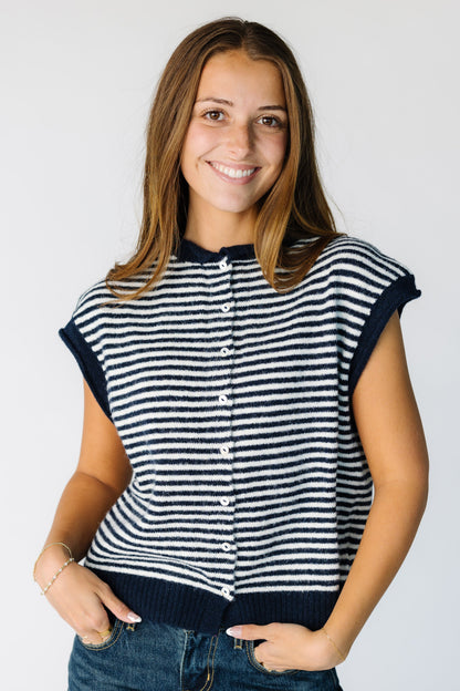 Woman wearing a short sleeve stripe sweater vest with functioning buttons in navy and white stripe.