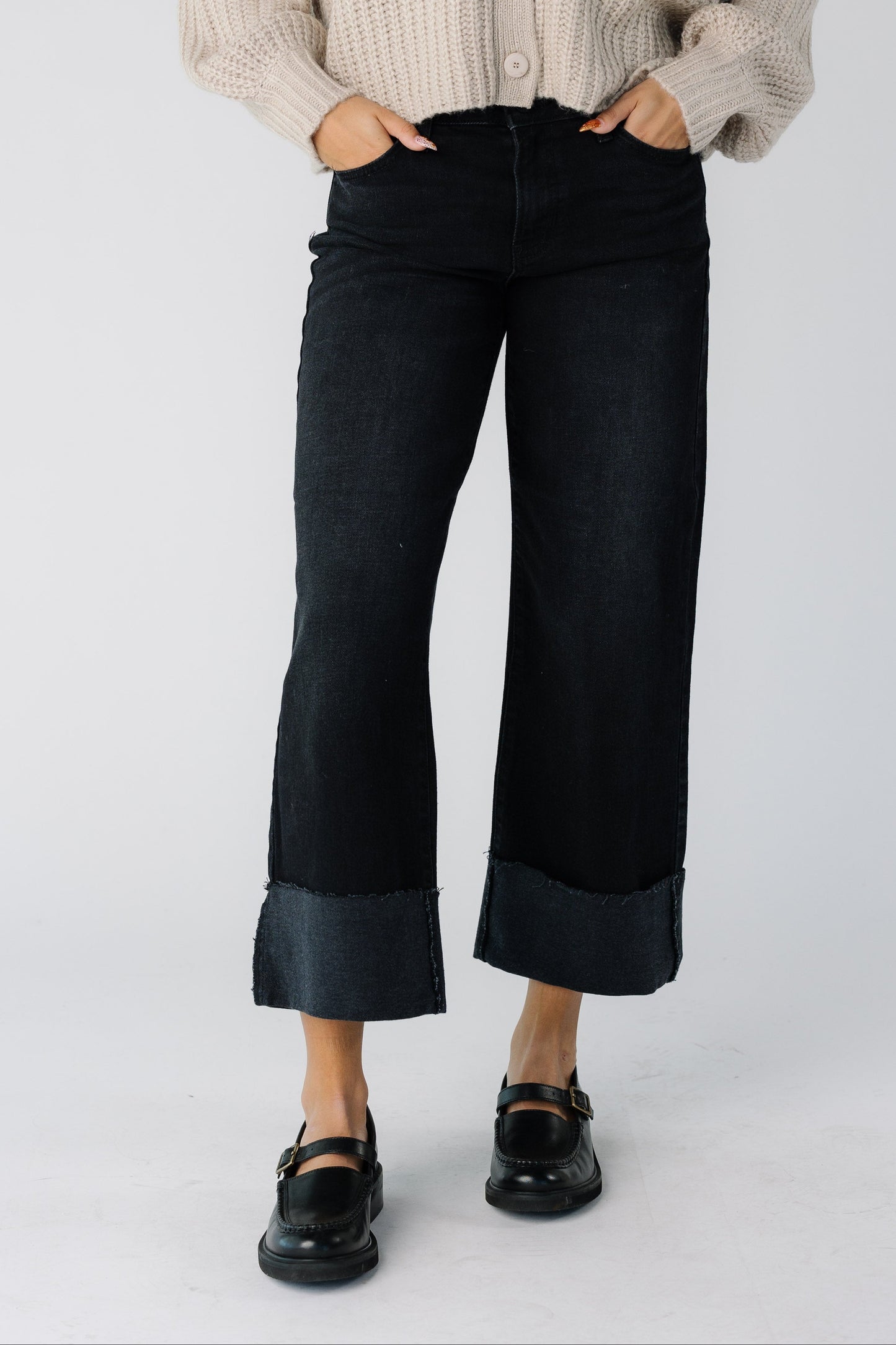 Teen girl wearing a pair of modest wide leg cuffed jeans in black