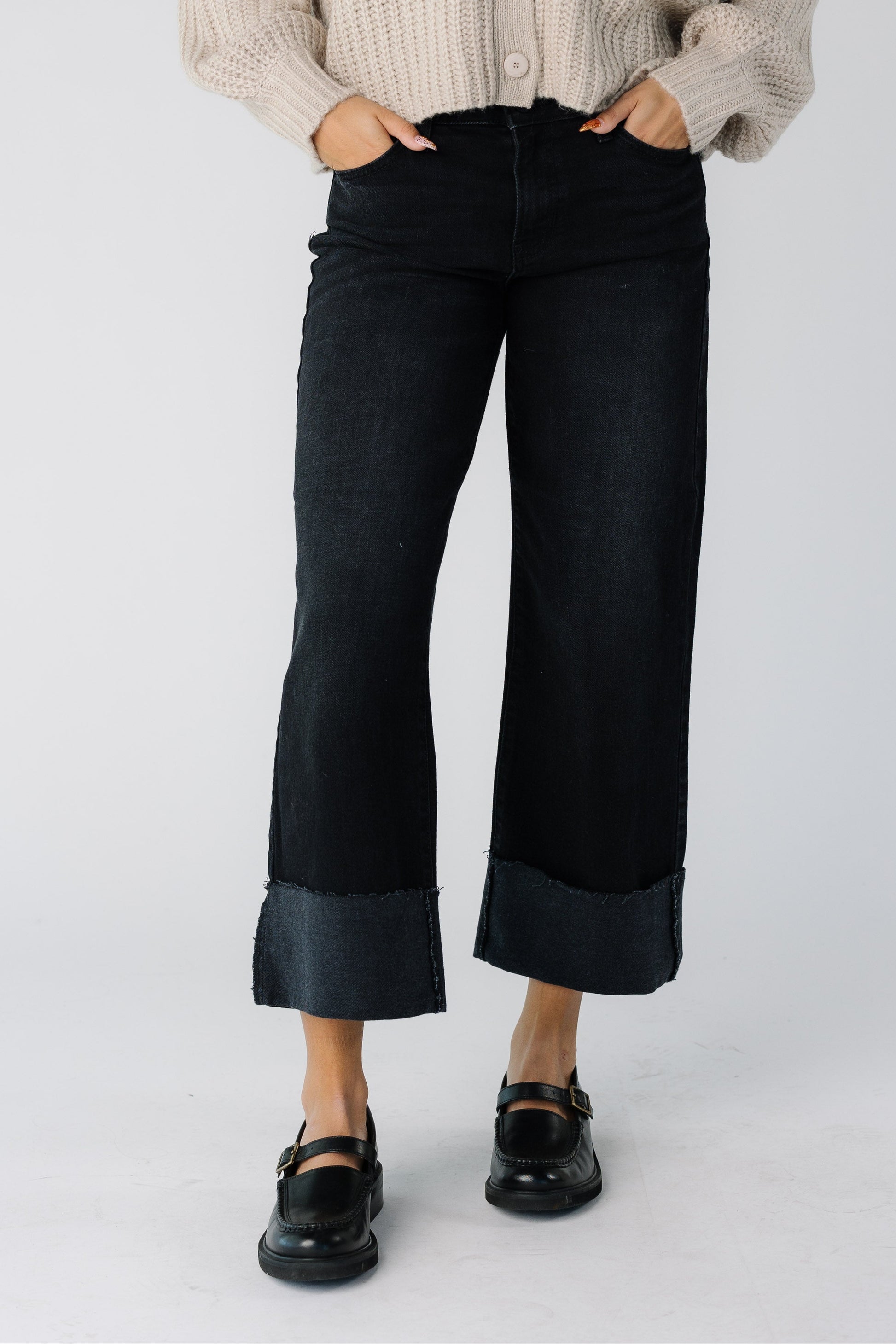 Teen girl wearing a pair of modest wide leg cuffed jeans in black