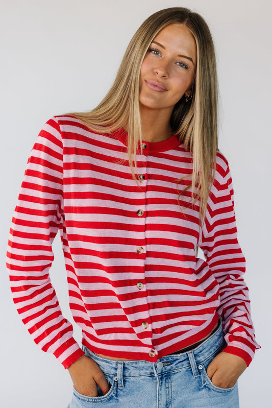 Woman wearing a pink and red stripe button down cardigan with long sleeves.