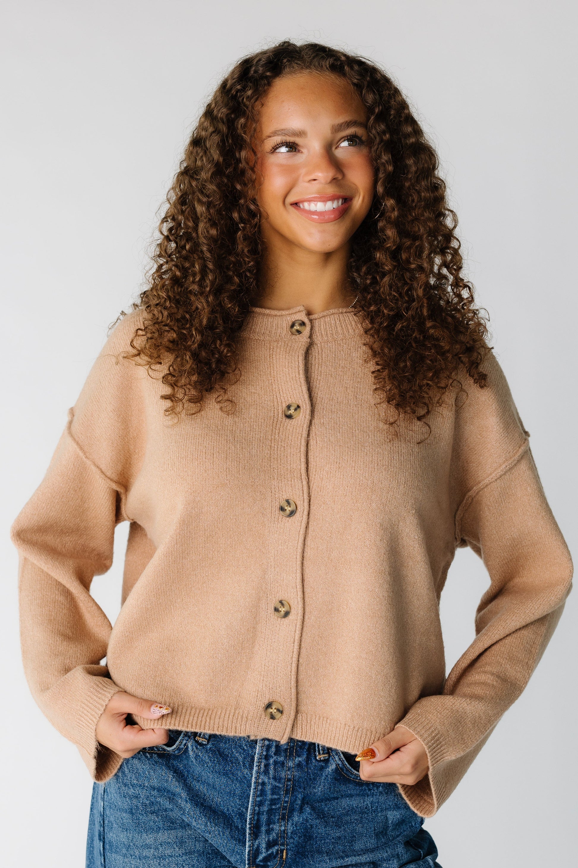 Woman wearing a modest long sleeve cardigan with exposed sleeves and a round collar 