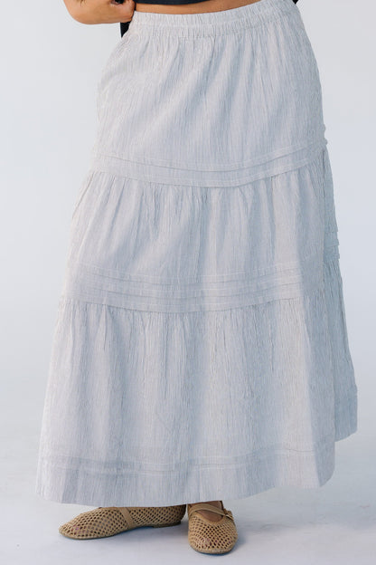 Woman wearing a vertical stripe skirt in brown and white with horizontal.