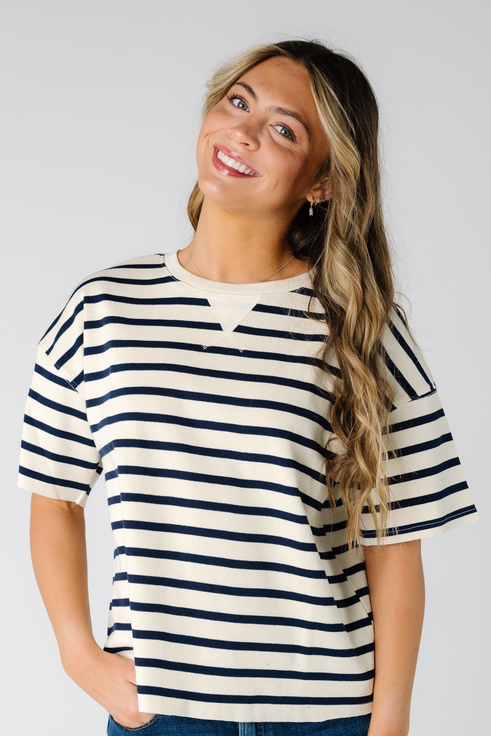 Woman wearing a modest white and black stripe tee with short sleeves.