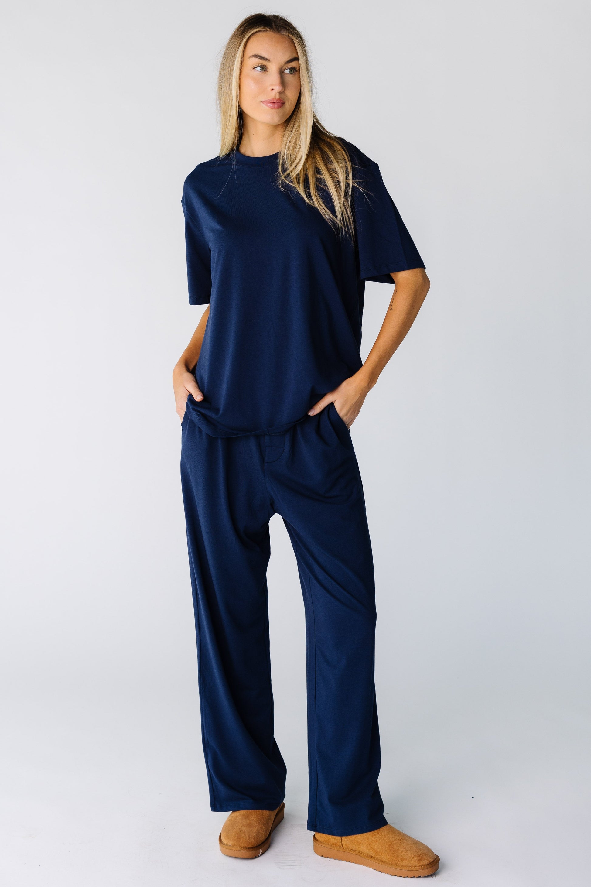 Woman wearing a short sleeve lounge set with long, wide cut pant with pockets