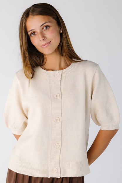 Woman wearing an ivory button down cardigan with full elbow length sleeves