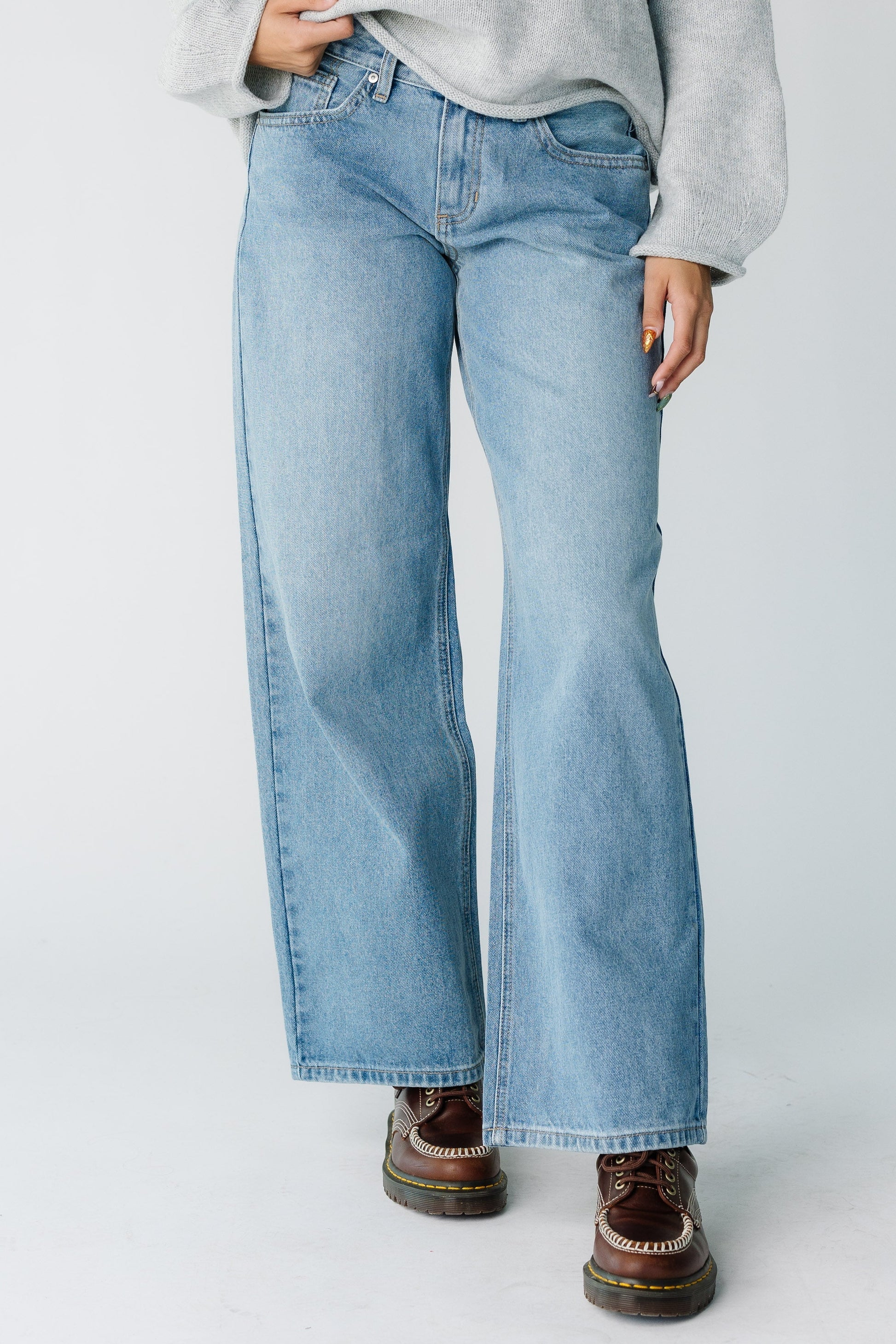 Woman wearing a loose fitting pair of medium denim jeans