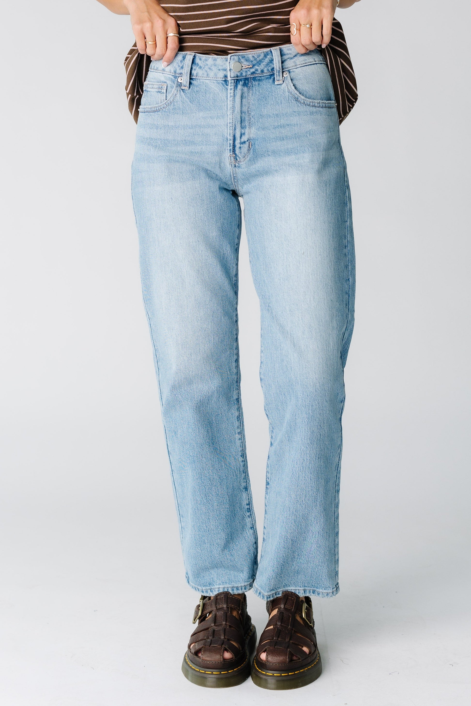 Woman wearing a  pair of light denim straight cut jeans.