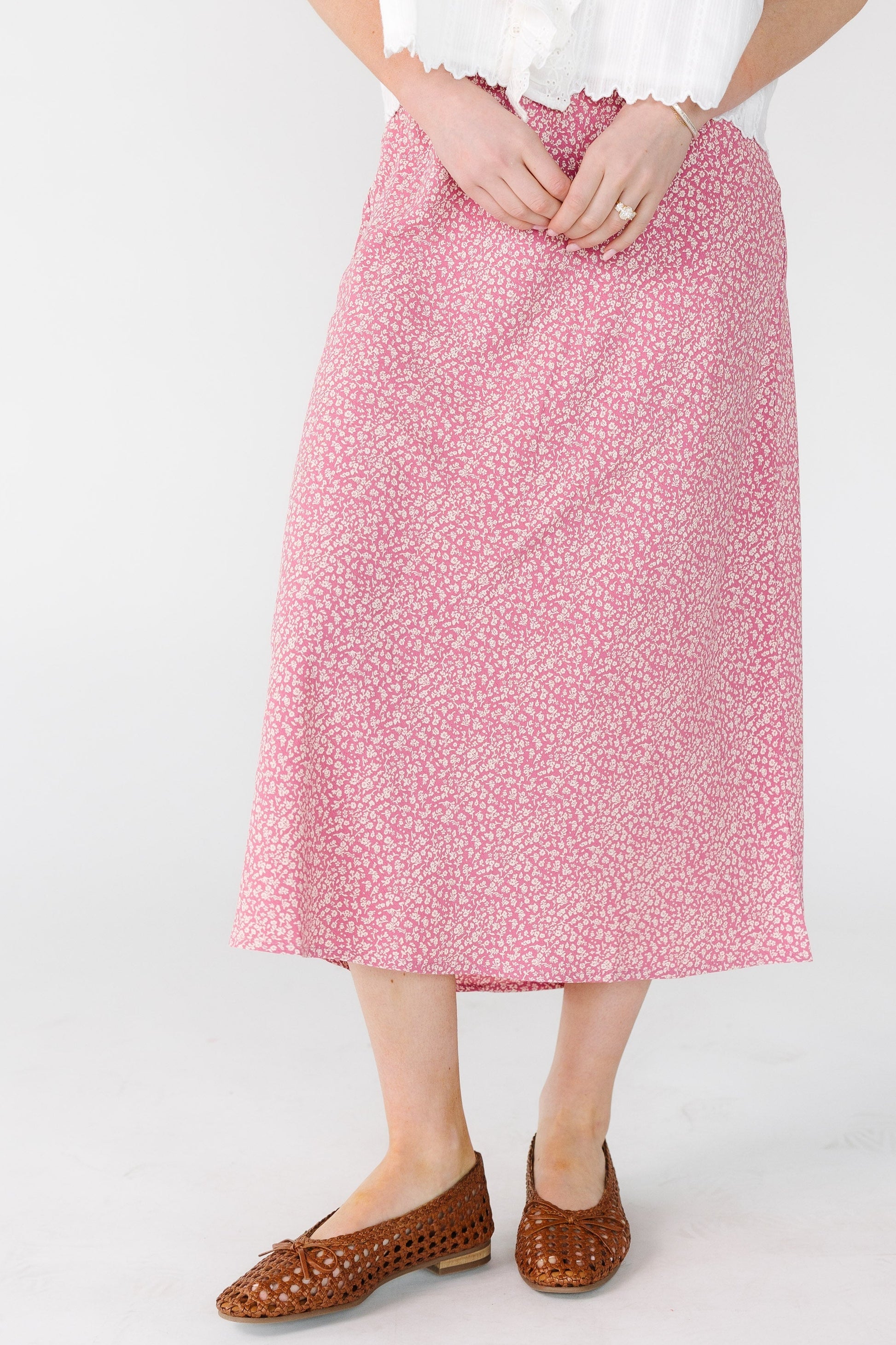 Young woman wearing a pink floral print midi skirt.
