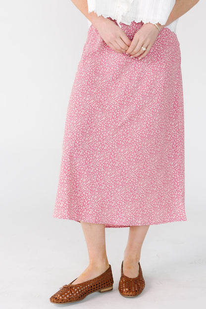 Young woman wearing a pink floral print midi skirt.
