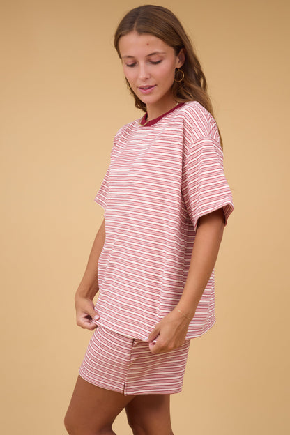 Young woman wearing a plush pink & white  short sleeve top.