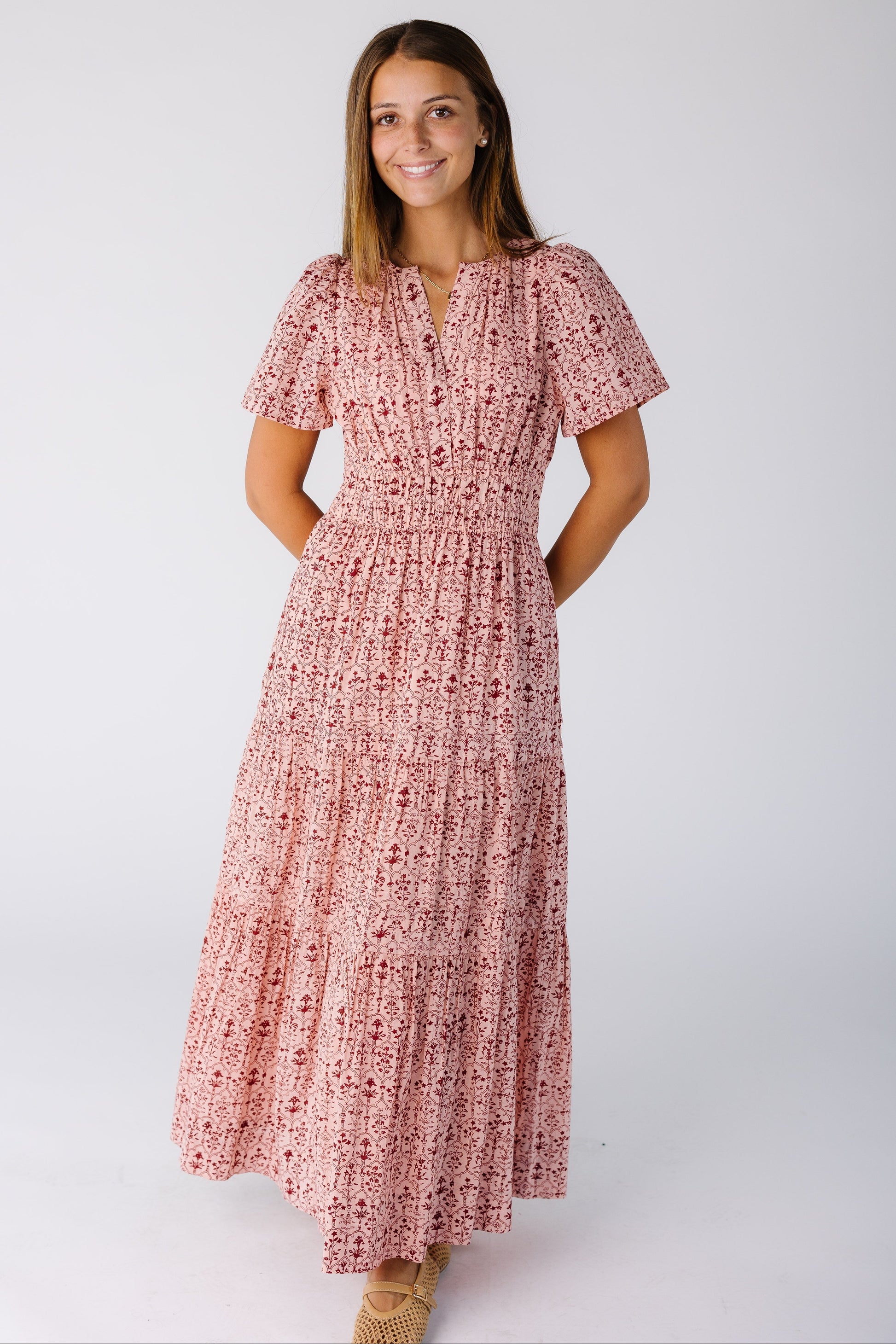 Woman wearing a pink print dress with full skirt and wide elastic waist