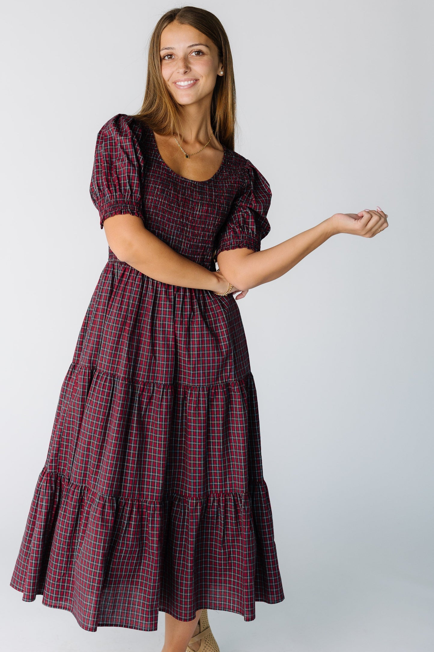 Woman wearing a red plaid midi dress with short sleeves and a full skirt