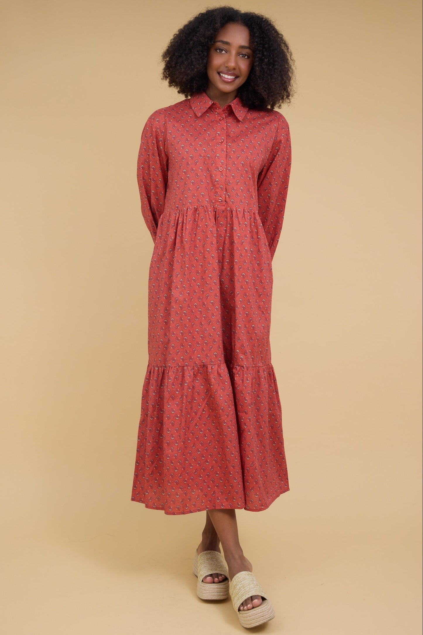 Young woman wearing a modest red midi dress with a pointed collar, button down bodice, long sleeves and a full gathered skirt.