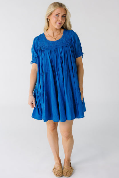 Woman wearing a modest knee length blue dress with a round eyelet lace yoke and neckline.
