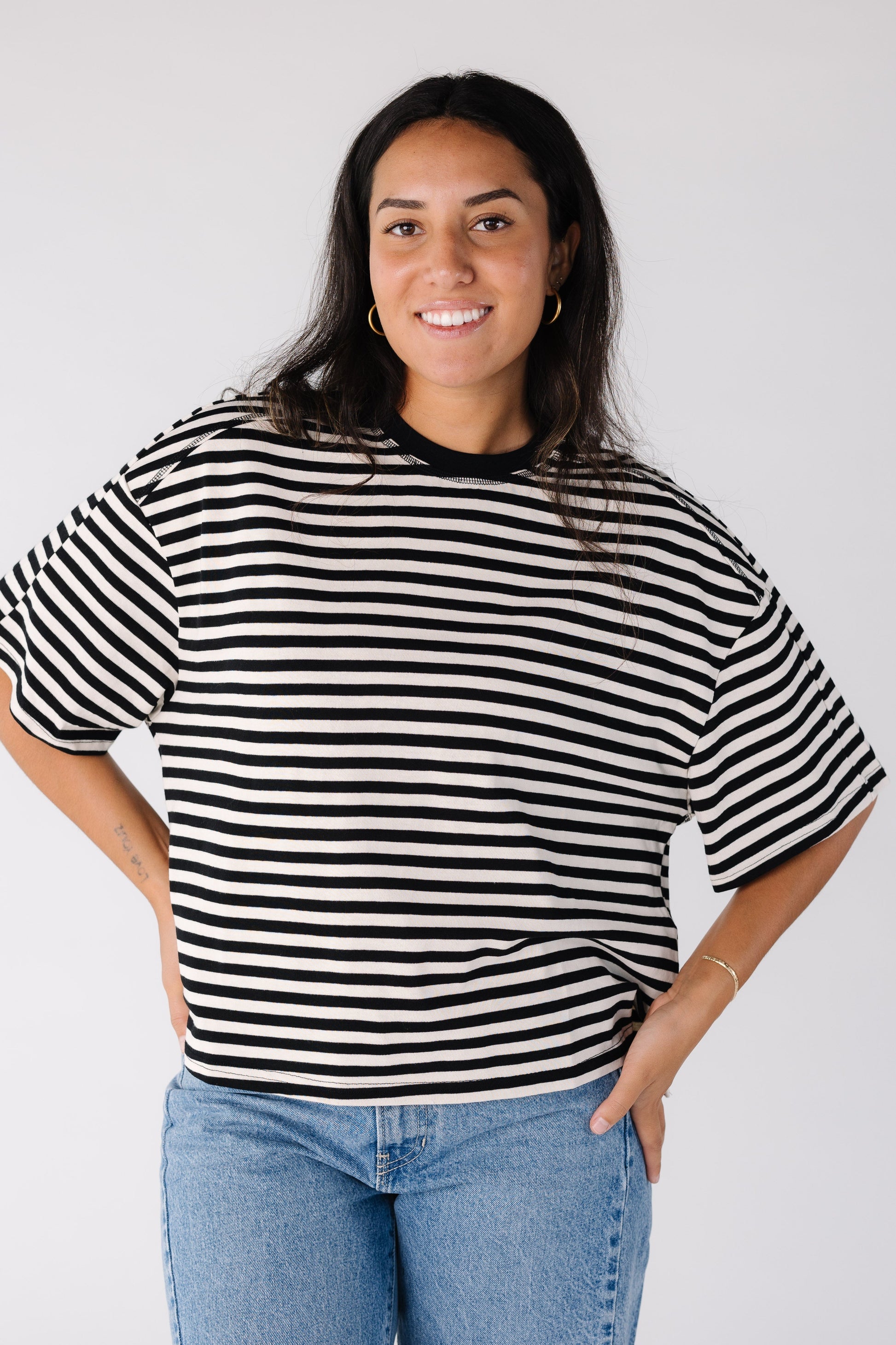 Woman wearing a black and white stripe boxy cut tee with short sleeves