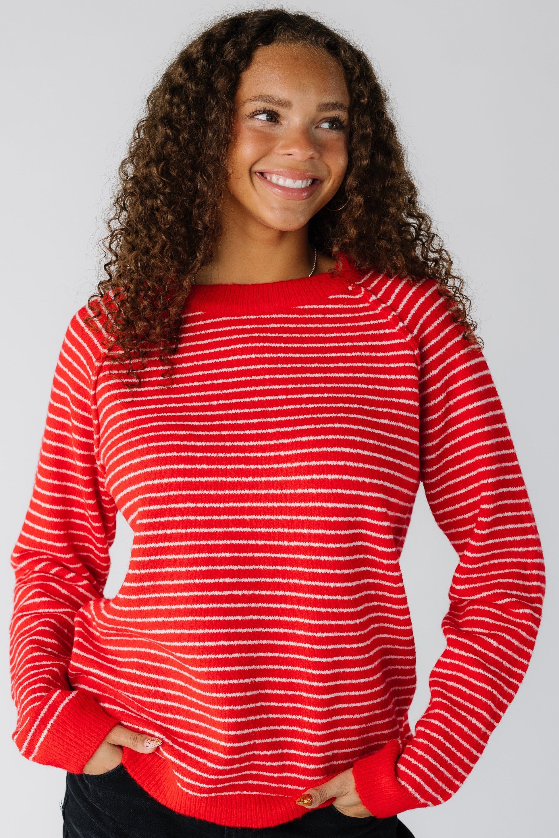 Woman wearing a red and white stripe pullover sweater with a crew neckline and long sleves