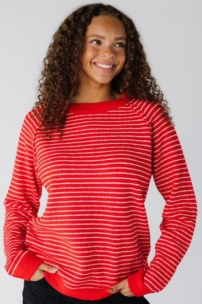 Woman wearing a red and white stripe pullover sweater with a crew neckline and long sleves