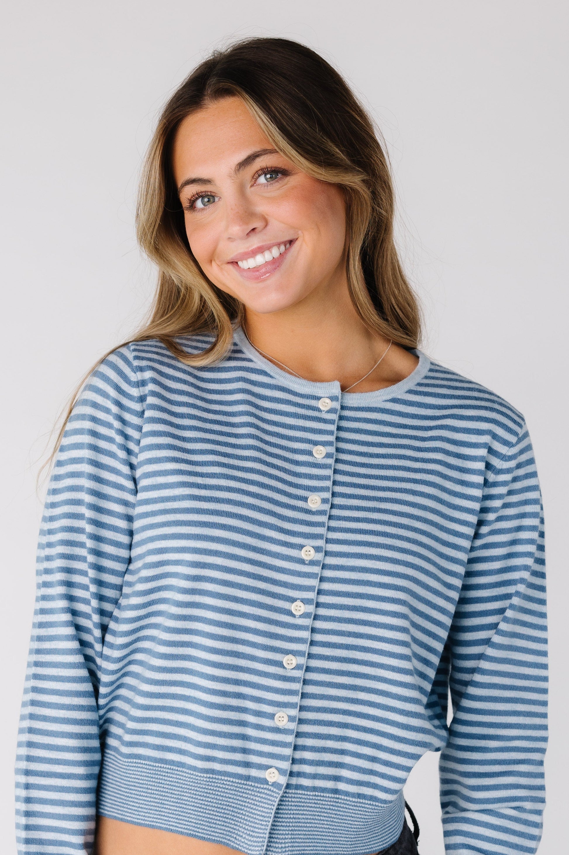 woman wearing a blue stripe cardigan with white buttons