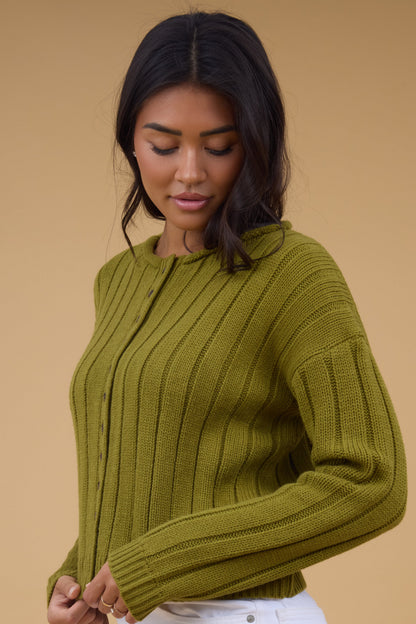 A side view of a woman wearing an olive wide ribbed cardigan with long sleeves.