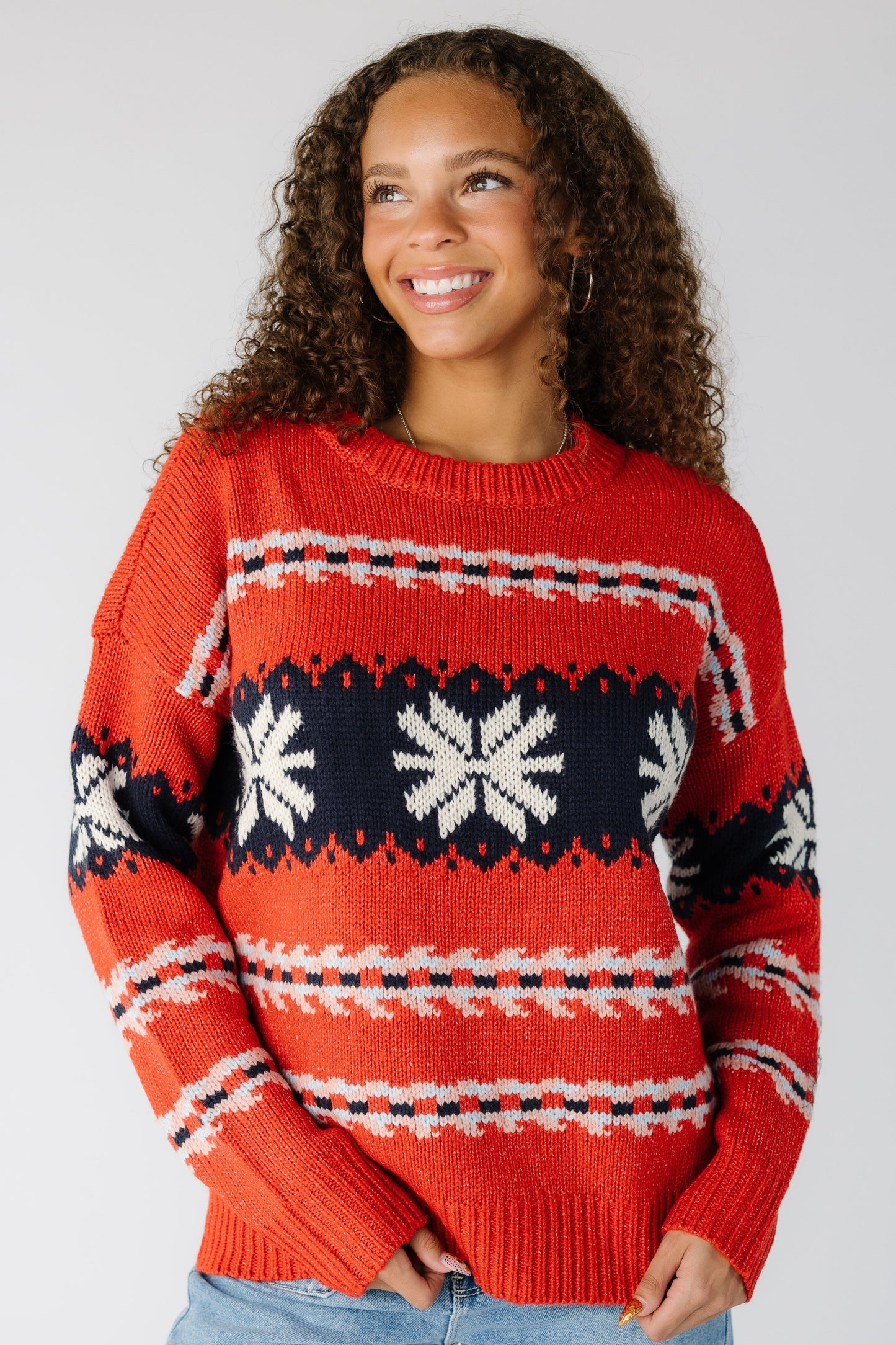 Woman wearing a red patterned pullover with long sleeves