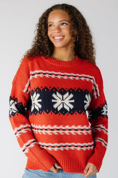 Woman wearing a red patterned pullover with long sleeves