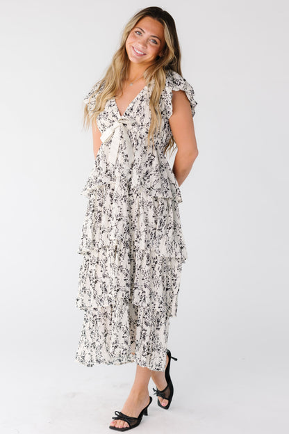 Woman wearing a white and black tiered dress with short sleeves and V-neckline