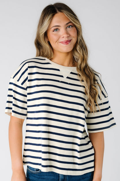 Woman wearing a white short sleeve tee with narrow black stripe.