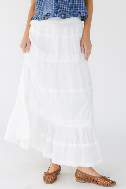 Young woman wearing a modest white tiered skirt with multiple rows of lace.