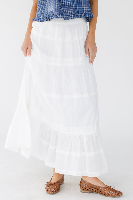 Young woman wearing a modest white tiered skirt with multiple rows of lace.