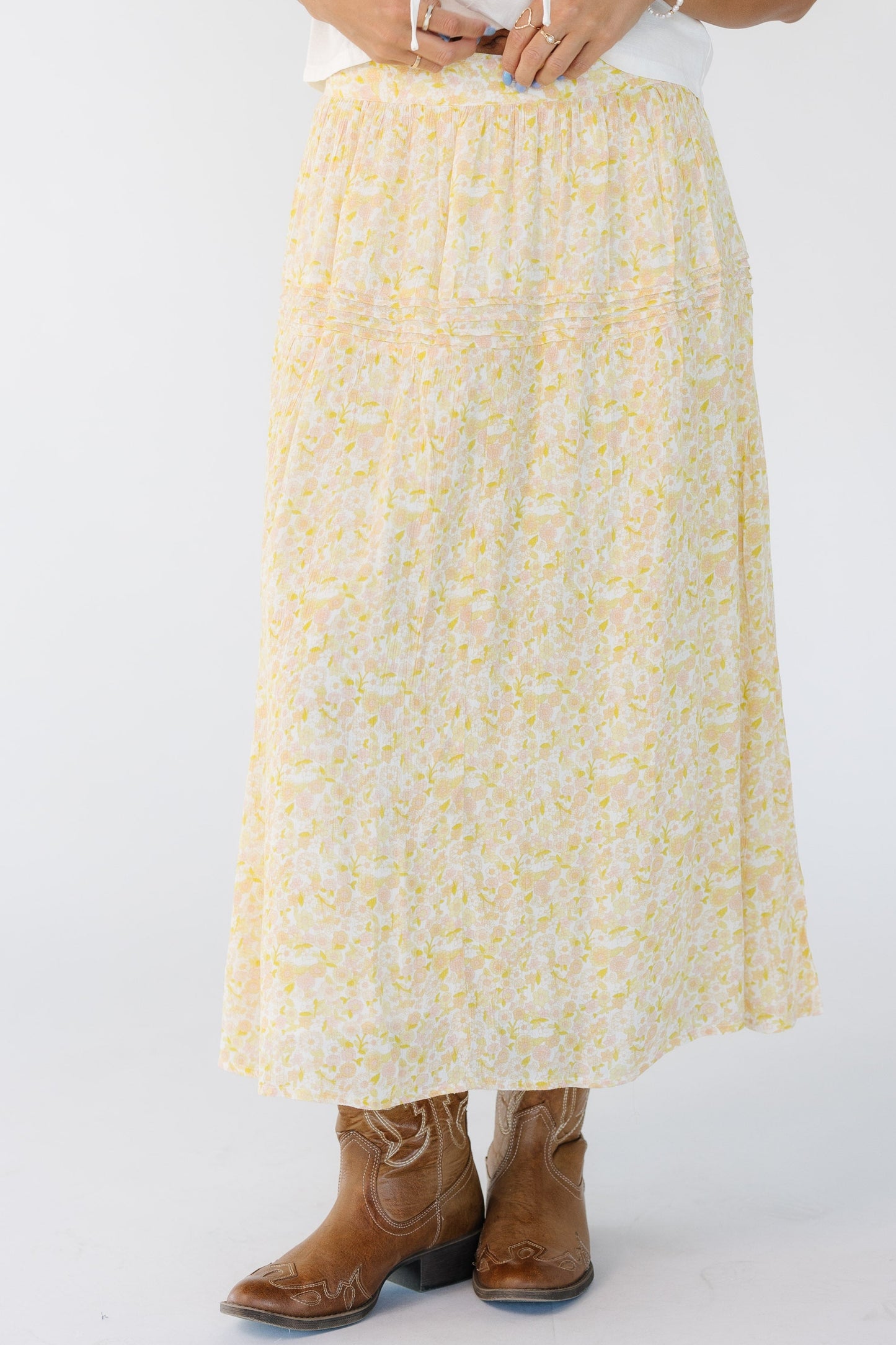 Woman wearing a modest yellow and white floral print midi skirt.
