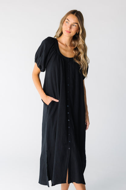 Woman wearing a black gauzy button down midi dress
