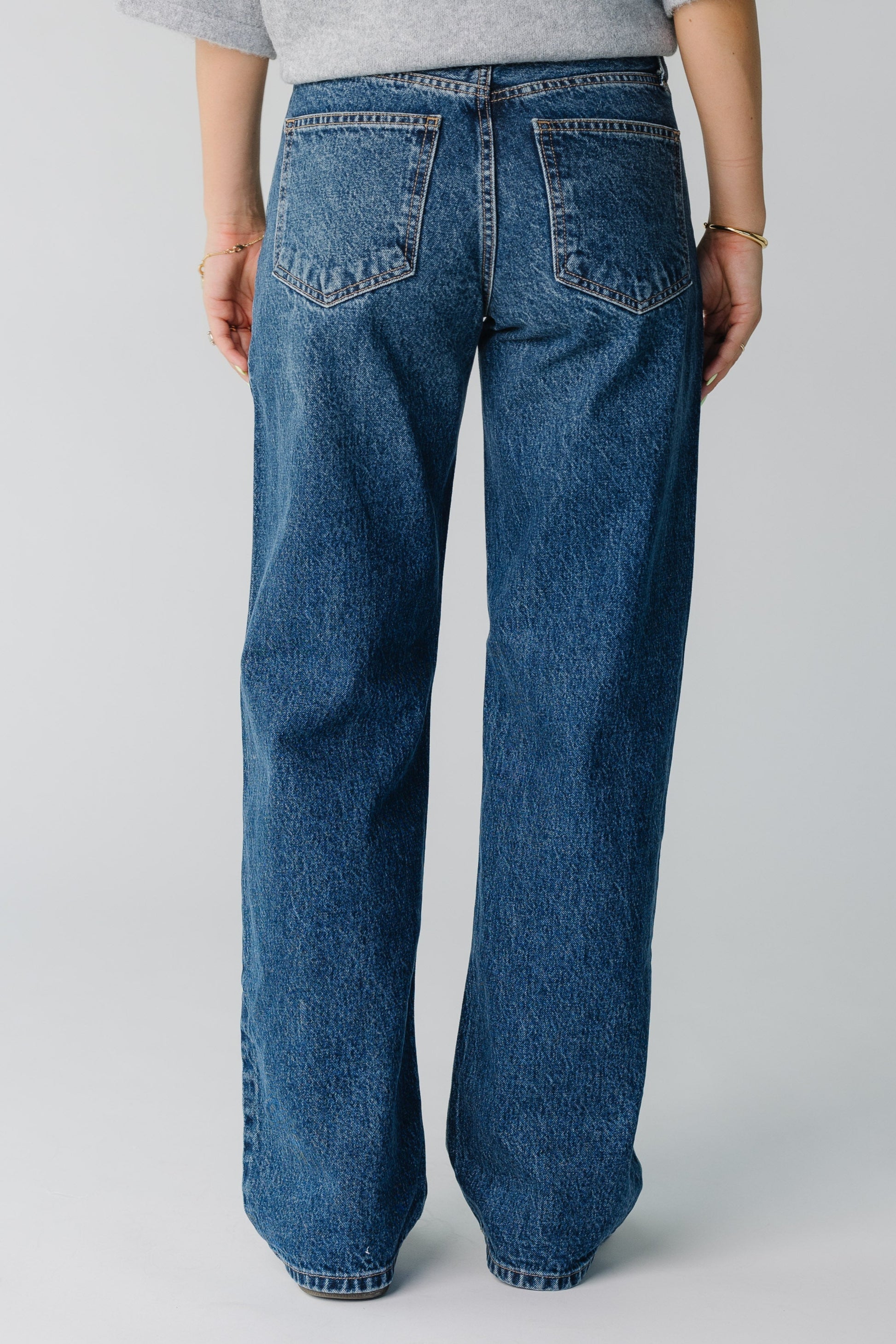 Back view of women's dark denim straight leg jeans