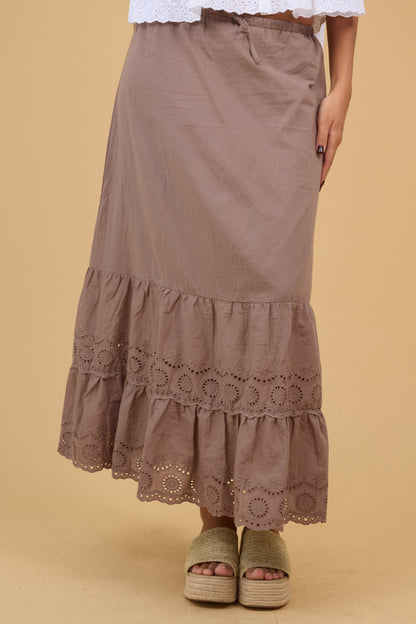 Young woman wearing a modest brown midi skirt with a wide double eyelet ruffle.