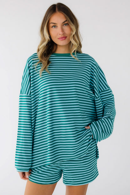 Woman wearing a green & blue stripe loose fitting shorts set with drop shoulders, long sleeves and elastic waist shorts.