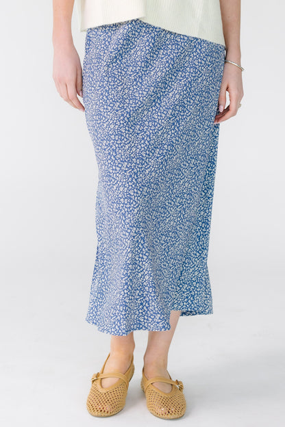 Woman wearing a modest navy and white A-line midi skirt.