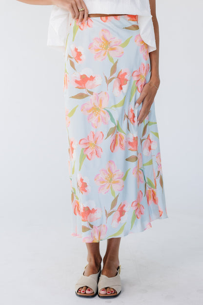 Woman wearing a blue A-line floral print midi skirt.