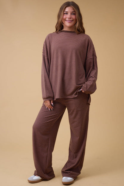 Young woman wearing a redish brown stripe lounge set with long sleeves and long pants.