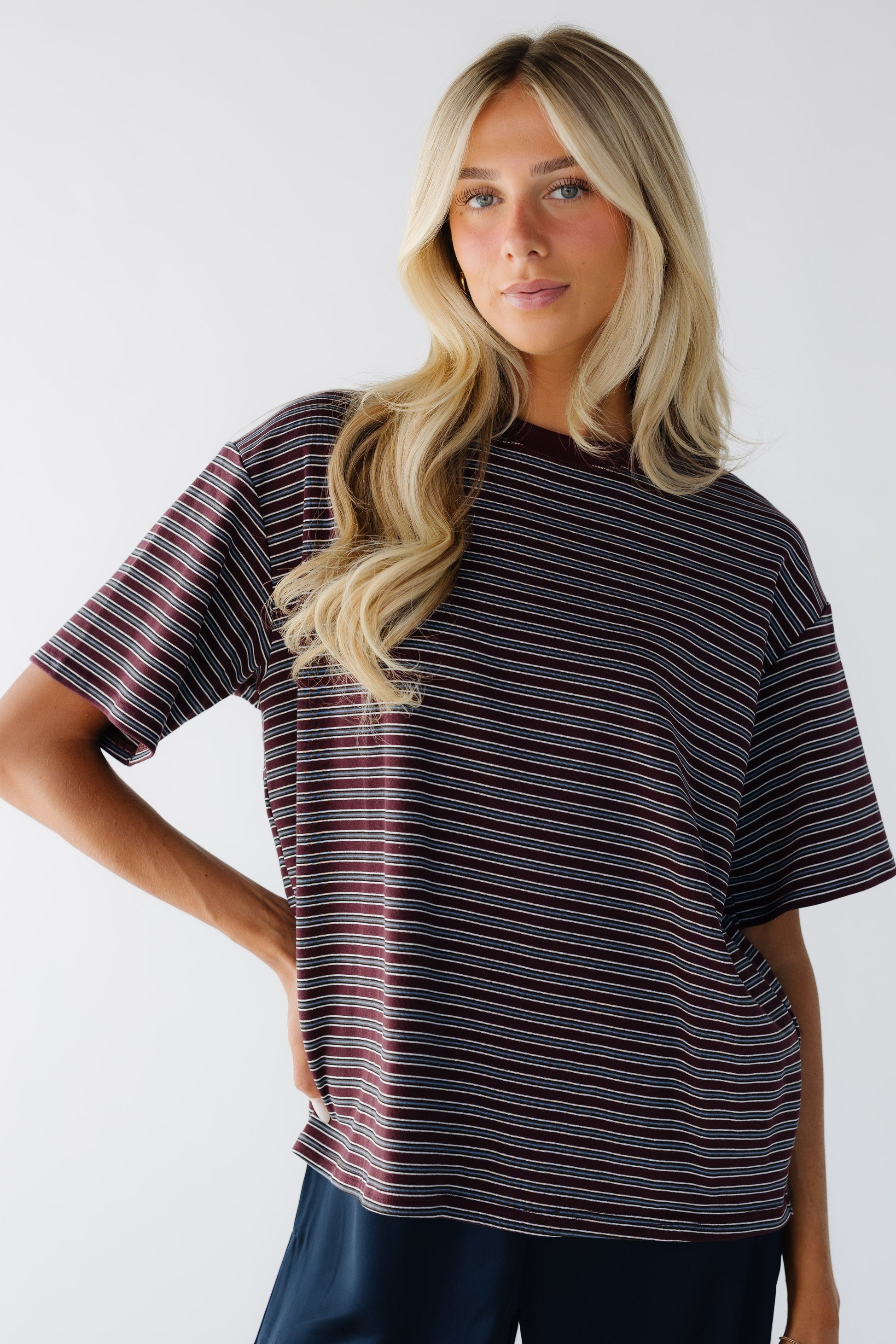 Young woman wearing a burgundy & grey stripe with short sleeves.