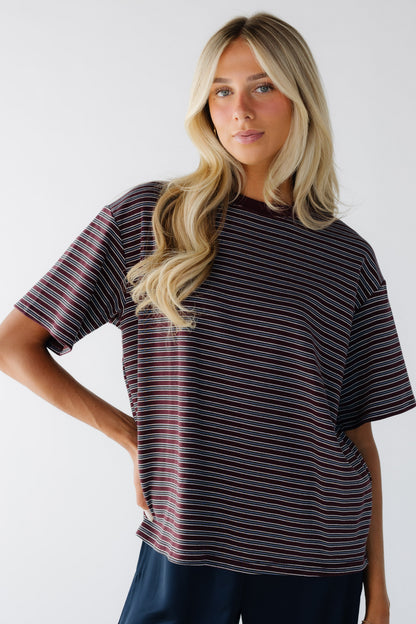 Young woman wearing a burgundy & grey stripe with short sleeves.