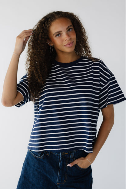 Teen age girl wearing a modest navy & white stripe loose fitting tee with short sleeves.